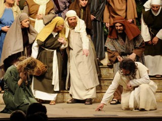 In a scene from East Auburn Baptist Church production of "The Event," Jesus, portrayed by Shawn DeGraff, writes in the dirt and asks the accusers, "He who is without sin, let him cast the first stone," when a woman caught in the act of adultery is brought before him, portrayed by Lisa Roy.