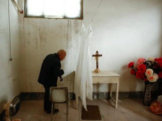 Pei Ronggui, an 81-year-old retired bishop waits to take confession from members of the congregation before Sunday service at an unofficial catholic church in Youtong village, Hebei Province, China, December 11, 2016. Picture taken December 11, 2016.    REUTERS/Thomas Peter