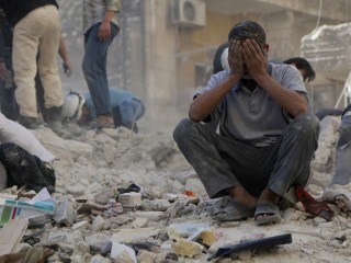 A man reacts amid debris after what activists said were explosive barrels thrown by forces loyal to Syria's President Bashar al-Assad in Al-Shaar neighbourhood of Aleppo April 27, 2014. REUTERS/Hosam Katan  (SYRIA - Tags: POLITICS CONFLICT TPX IMAGES OF THE DAY) - RTR3MTUG