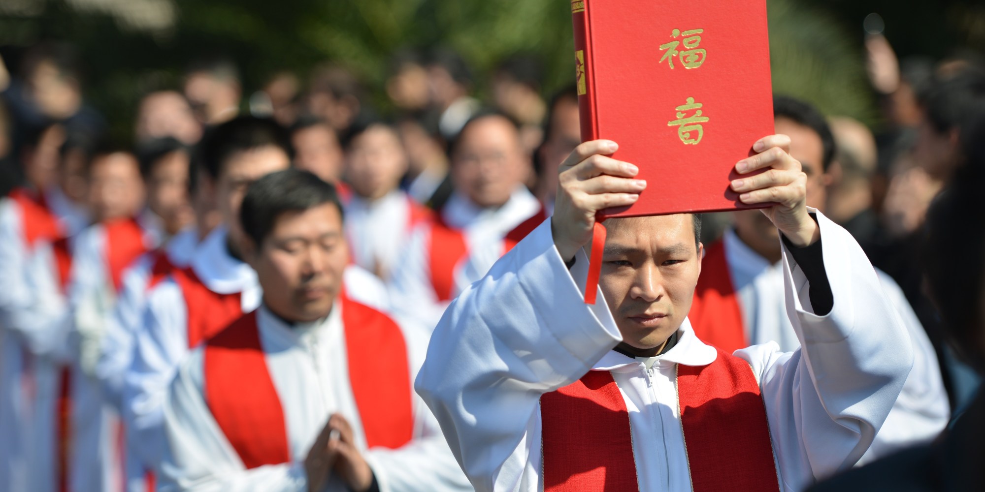 Clergy arrive for the funeral of the late head of the underground Catholic Church in Shanghai, Bishop Joseph Fan Zhongliang, as he lies in a funeral home in Shanghai on March 22, 2014. Thousands of mourners packed the funeral home to bid farewell to the "underground" Catholic Bishop whose faith, they said, led him to endure decades of suffering at the hands of China's ruling Communist Party. AFP PHOTO/Peter PARKS (Photo credit should read PETER PARKS/AFP/Getty Images)