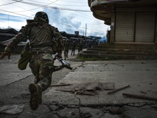MARAWI CITY, PHILIPPINES - MAY 25: Soldiers run for cover to evade sniper fire while trying to clear the city of armed militants, one street at a time, on May 25, 2017 in Marawi city, southern Philippines. Gun battles between ISIS-linked militants and Filipino troops erupted in Marawi city on Tuesday when gunmen from the local terrorist groups Maute Group and Abu Sayyaf rampaged through the southern city, prompting President Rodrigo Duterte to declare 60 days of martial law in Mindanao. Thousands of residents were reported to have fled from Malawi city while at least 21 people were killed, including a police chief who had been beheaded and buildings were torched by the terror groups. President Duterte said the influence of Islamic State is one of the nation's top security concerns, and martial law on Mindanao island could be extended across the Philippines to enforce order, allowing the detention of people without charge. (Photo by Jes Aznar/Getty Images)
