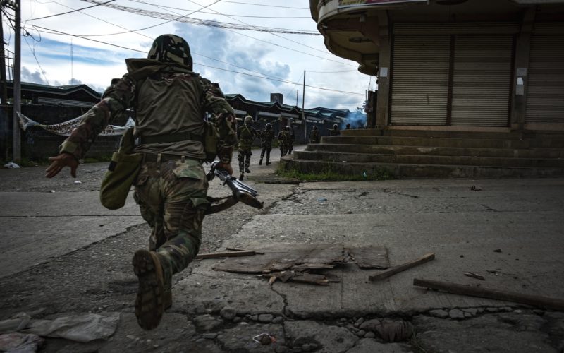 MARAWI CITY, PHILIPPINES - MAY 25: Soldiers run for cover to evade sniper fire while trying to clear the city of armed militants, one street at a time, on May 25, 2017 in Marawi city, southern Philippines. Gun battles between ISIS-linked militants and Filipino troops erupted in Marawi city on Tuesday when gunmen from the local terrorist groups Maute Group and Abu Sayyaf rampaged through the southern city, prompting President Rodrigo Duterte to declare 60 days of martial law in Mindanao. Thousands of residents were reported to have fled from Malawi city while at least 21 people were killed, including a police chief who had been beheaded and buildings were torched by the terror groups. President Duterte said the influence of Islamic State is one of the nation's top security concerns, and martial law on Mindanao island could be extended across the Philippines to enforce order, allowing the detention of people without charge. (Photo by Jes Aznar/Getty Images)