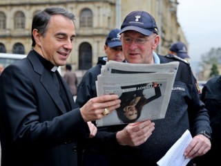 Archbishop Ettore Balestrero, apostolic nuncio to Colombia, and Domenico Giani, Pope Francis' lead bodyguard, look at a newspaper during a May 8 walk through the streets in downtown Bogota. The pope is scheduled to visit four Colombian cities, starting his trip in the Bogota, the capital, Sept. 6, followed by day trips to Villavicencio and Medellin Sept. 8 and 9, and Mass in Cartagena Sept. 10. (CNS photo/Leonardo Munoz, EPA) See COLOMBIA-POPE June 23, 2017.