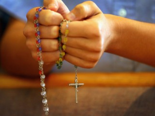 MIAMI, FL - DECEMBER 21: A child holds rosary beads as she prays during a service at St. Rose of Lima School, for the victims of  the school shooting one week ago in Newtown, Connecticut on December 21, 2012 in Miami, Florida. Across the country people marked the one week point since the shooting at Sandy Hook Elementary School in Newtown, Connecticut that killed 26 people.  (Photo by Joe Raedle/Getty Images)