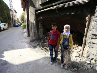 12_year_old_twins_from_the_old_city_of_Homs_stand_near_garbage_outside_a_dilapidated_building_Credit___UNICEF_UNI201161_Ohanesian_CNA_1_13_16