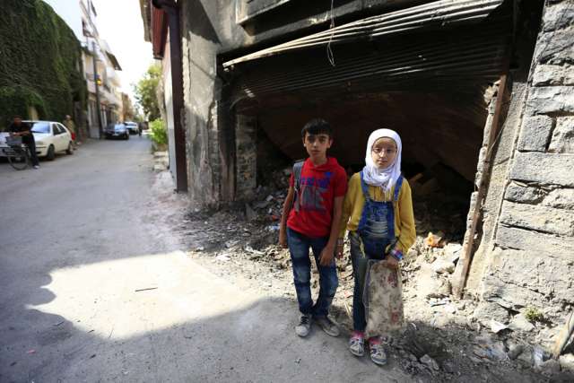 12_year_old_twins_from_the_old_city_of_Homs_stand_near_garbage_outside_a_dilapidated_building_Credit___UNICEF_UNI201161_Ohanesian_CNA_1_13_16