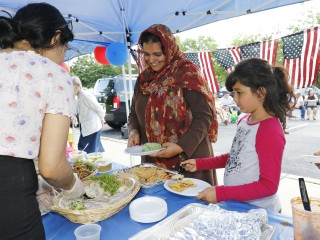 A Pakistani woman and her daughter stand in a buffet line during a Catholic Charities-hosted party for refugees held in observance of World Refugee Day June 20 in Amityville, N.Y. (CNS photo/Gregory A. Shemitz) See POPE-SHARE-JOURNEY Sept. 27, 2017.