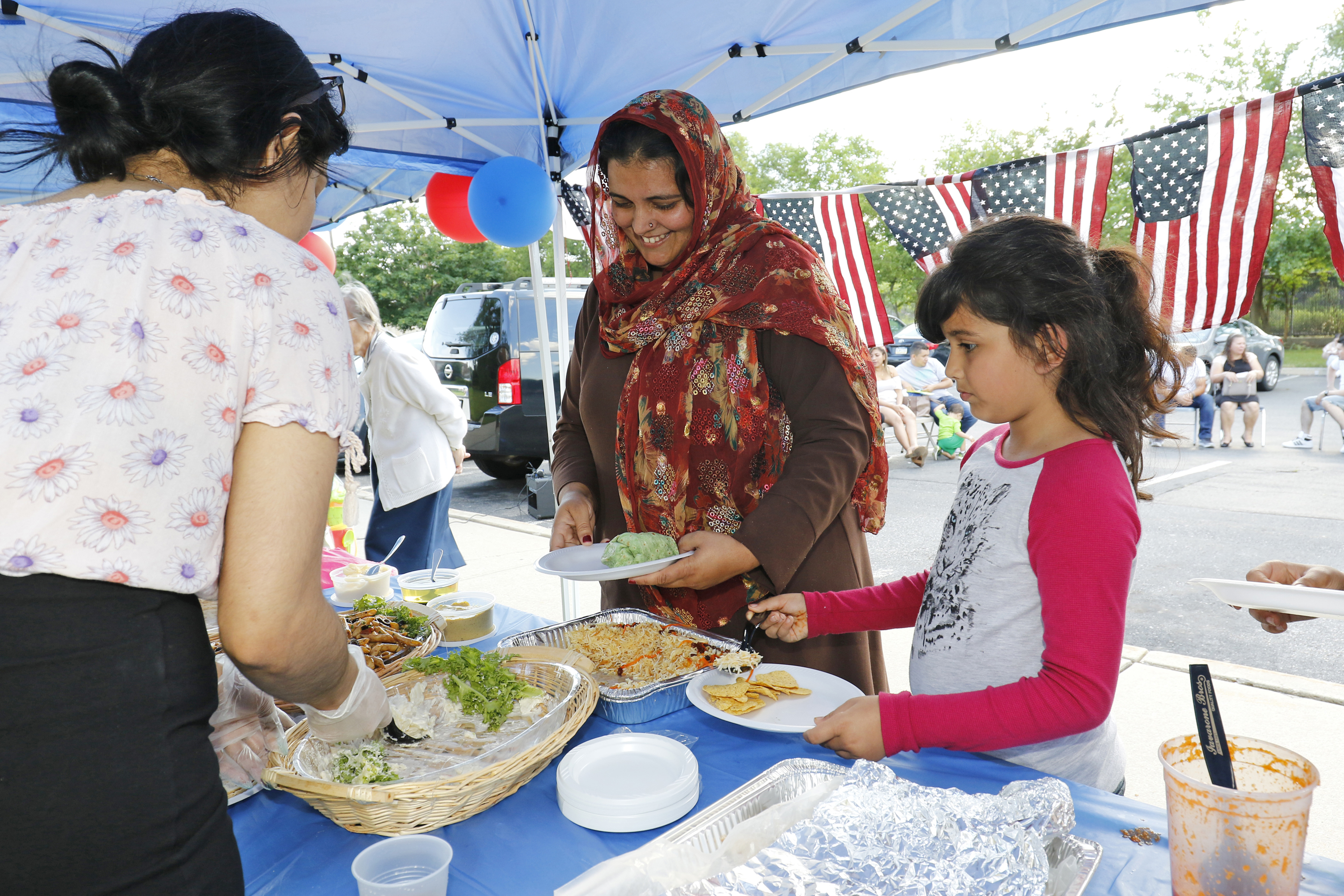 A Pakistani woman and her daughter stand in a buffet line during a Catholic Charities-hosted party for refugees held in observance of World Refugee Day June 20 in Amityville, N.Y. (CNS photo/Gregory A. Shemitz) See POPE-SHARE-JOURNEY Sept. 27, 2017.