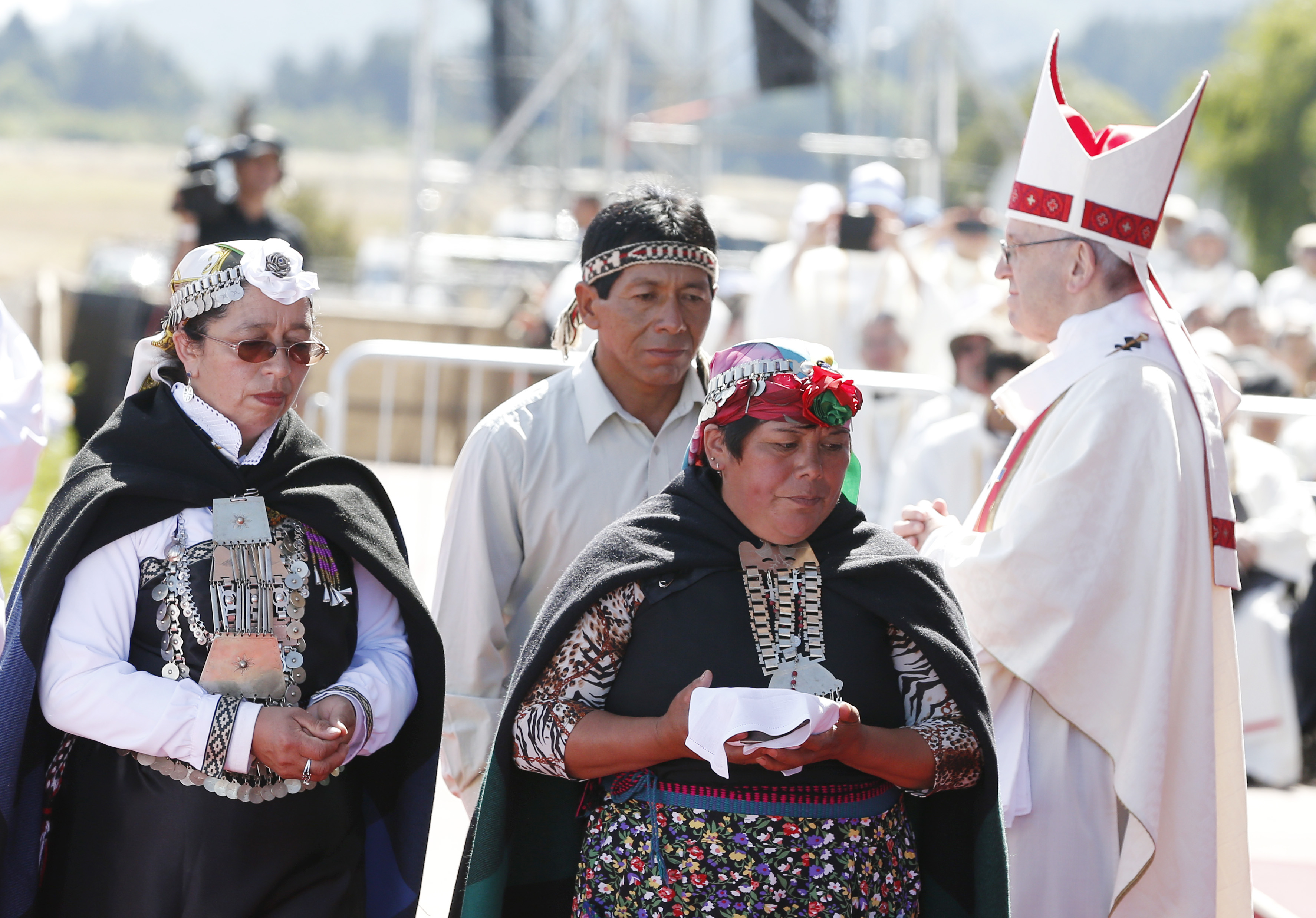 Indigenous people walk past Pope Francis after presenting offertory gifts during the pope's celebration of Mass at the Maquehue Airport near Temuco, Chile, Jan. 17. (CNS photo/Paul Haring) See POPE-TEMUCO-MASS Jan. 17, 2018.