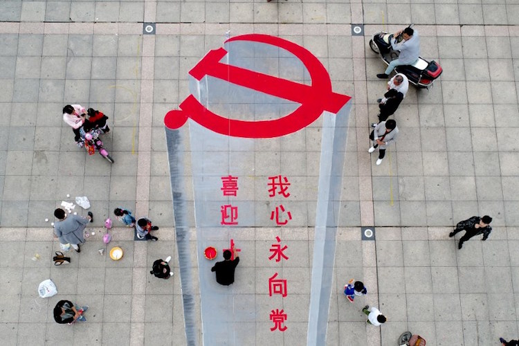 This photo taken on October 6, 2017 shows a man working on a 3D street painting of the emblem of Chinese Communist Party to celebrate the upcoming Party Congress in Xiayi in China's central Henan province.  China will convene its 19th Party Congress on October 18, state media said, a key meeting held every five years where President Xi Jinping is expected to receive a second term as the ruling Communist Party's top leader. / AFP PHOTO / STR / China OUT