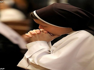 một nữ tu đang cầu nguyện - AP