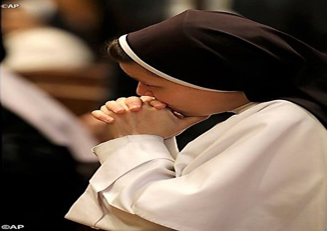 một nữ tu đang cầu nguyện - AP