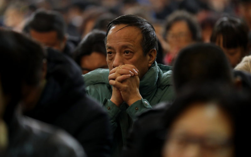 A man prays during a 2017 Mass at the Cathedral of the Immaculate Conception in Beijing. As rumors fly of an imminent Vatican-China deal on the appointment of bishops, a Belgian priest known as an expert on China said he thinks an agreement might really happen. (CNS photo/Wu Hong) See CHINA-DEAL-HEYNDRICKX March 21, 2018.