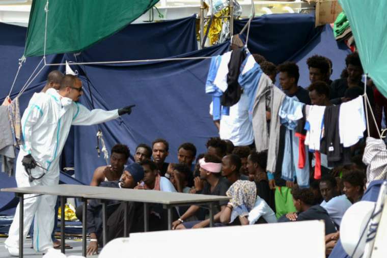 Migrants_on_the_the_Italian_Coast_Guard_vessel_Diciotti_wait_to_embark_Credit__Giovanno_Isolino_AFP_Getty_Images