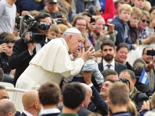 Pope Francis kisses a toddler's head as he arrives on the popemobile car for the weekly general audience on October 17, 2018 at St. Peter's square in the Vatican. (Photo by Tiziana FABI / AFP)