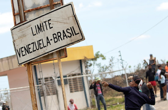 epa07394189 Venezuelans face the Police of the National Guard on the border between Pacaraima, Brazil and Venezuel, on 24 February 2019. Some 20 anti-Chavistas were dispersed this Sunday in the Brazilian border with Venezuela, after provoking Venezuelan agents blocking the border, closed by order of the Government of Nicolás Maduro to prevent the entry of humanitarian aid. EPA/Joedson Alves (MaxPPP TagID: epalivethree904153.jpg) [Photo via MaxPPP]