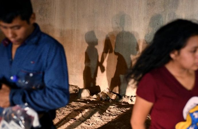 Những người xin tị nạn tại Hidalgo, Texas, quay lưng lại với các sĩ quan Biên phòng Hoa Kỳ hôm 23 tháng 8 năm 2019. (Ảnh:Loren Elliott/Reuters)