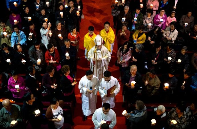 Trong bức ảnh hôm thứ Bảy ngày 31/3/2018 này, Đức Giám mục Joseph Li Shan đang bước xuống lối đi giữa nhà thờ trong Thánh Lễ Canh Thức Vọng Phục sinh tại Nhà thờ Chính Tòa Đức Mẹ Vô Nhiễm Nguyên Tội, một nhà thờ Công giáo được chính phủ phê chuẩn ở Bắc Kinh. (Ảnh: Mark Schiefelbein/AP)