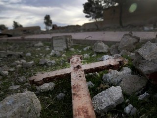 Bức ảnh hôm 1 tháng 4 năm 2018 này, cho thấy cảnh một cây Thánh giá nằm trong đống đổ nát của một nhà thờ bị phá hủy bởi phiến quân Nhà nước Hồi giáo vào năm 2015, tại ngôi làng hoang vắng Tal Jazeera, miền bắc Syria. Mạng lưới Nhân quyền Syria có trụ sở tại Qatar, một giám sát viên cuộc chiến Syria có sự kết nối với phe đối lập cho biết trong báo cáo hôm thứ Hai, ngày 9 tháng 9 năm 2019, rằng hơn 120 cơ sở thờ phượng Kitô giáo đã bị hư hoại hoặc bị phá hủy bởi tất cả các bên trong cuộc xung đột kéo dài suốt 8 năm ròng trong nước. (Ảnh: Hussein Malla/AP)