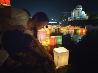 Một phụ nữ đặt một chiếc đèn lồng trên sông vào ngày 6 tháng 8 năm 2015, tại thành phố Hiroshima, Nhật Bản, kỷ niệm 70 năm vụ đánh bom nguyên tử xuống thành phố. Phụ tá hàng đầu của ĐTC Phanxicô đã không giấu giếm những suy nghĩ của Đức Thánh Cha khi Ngài đến thăm thành phố Hiroshima và Nagasaki, Nhật Bản, vào ngày 24/11: "loại bỏ hoàn toàn vũ khí hạt nhân" (Ảnh: CNS / Paul Jeffrey)