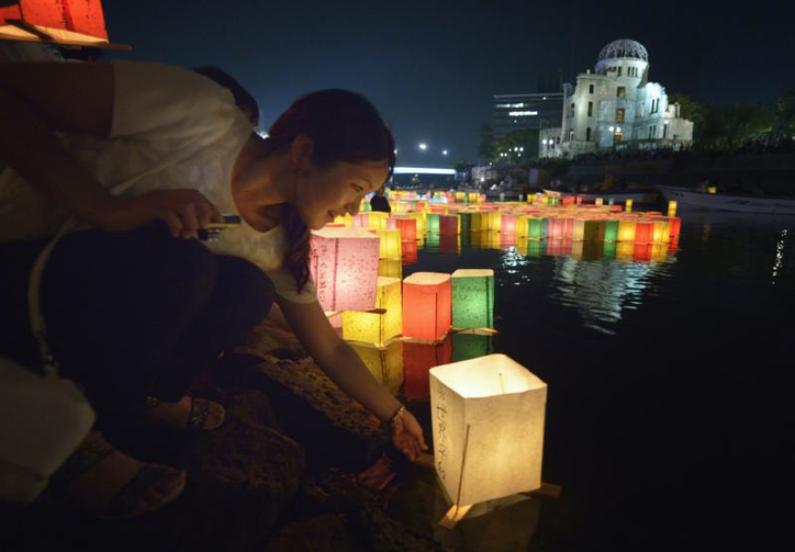 Một phụ nữ đặt một chiếc đèn lồng trên sông vào ngày 6 tháng 8 năm 2015, tại thành phố Hiroshima, Nhật Bản, kỷ niệm 70 năm vụ đánh bom nguyên tử xuống thành phố. Phụ tá hàng đầu của ĐTC Phanxicô đã không giấu giếm những suy nghĩ của Đức Thánh Cha khi Ngài đến thăm thành phố Hiroshima và Nagasaki, Nhật Bản, vào ngày 24/11: "loại bỏ hoàn toàn vũ khí hạt nhân" (Ảnh: CNS / Paul Jeffrey)