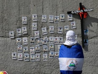 Một người biểu tình gần Nhà thờ lớn Metropolitan ở Managua, Nicaragua, nhìn vào hình ảnh ngày 2 tháng 11 năm 2019, về những người biểu tình đã chết trong cuộc biểu tình chống lại chính phủ của Tổng thống Daniel Ortega năm ngoái. (Tín dụng: Oswaldo Rivas / Reuters qua CNS.)