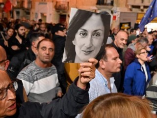 Công dân Malta giữ tấm bảng của Daphne Caruana Galizia trong một cuộc biểu tình
