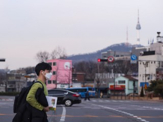 Một người đàn ông đi bộ trên đường phố ở Seoul, Hàn Quốc, ngày 24 tháng 2 năm 2020. Hàn Quốc đã xác nhận thêm 231 trường hợp mắc COVID-19 vào thứ Hai, nâng tổng số ca nhiễm bệnh lên 833 và số người chết tăng lên tám. (Tân Hoa Xã / Wang Jingqiang / MaxPPP)