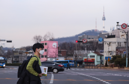 Một người đàn ông đi bộ trên đường phố ở Seoul, Hàn Quốc, ngày 24 tháng 2 năm 2020. Hàn Quốc đã xác nhận thêm 231 trường hợp mắc COVID-19 vào thứ Hai, nâng tổng số ca nhiễm bệnh lên 833 và số người chết tăng lên tám. (Tân Hoa Xã / Wang Jingqiang / MaxPPP)