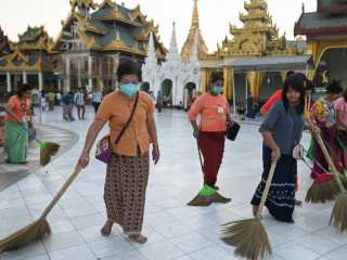 Các tình nguyện viên đeo mặt nạ giữa những lo ngại về sự lây lan của coronavirus quét sàn chùa Shwedagon ở Yangon vào ngày 13 tháng 3. (Ảnh: Ye Aung Thu / AFP)