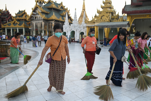 Các tình nguyện viên đeo mặt nạ giữa những lo ngại về sự lây lan của coronavirus quét sàn chùa Shwedagon ở Yangon vào ngày 13 tháng 3. (Ảnh: Ye Aung Thu / AFP)