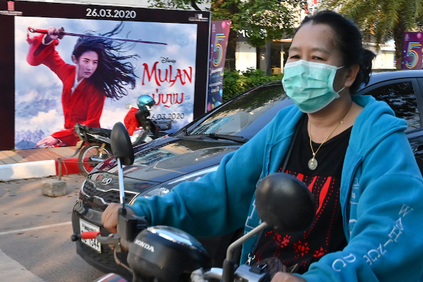 Một phụ nữ đeo mặt nạ giữa những lo ngại về sự lây lan của coronavirus đi xe máy ở Viêng Chăn, thủ đô của Lào, vào ngày 11 tháng 3. Quốc gia nghèo khó này vẫn chưa báo cáo một trường hợp nào về Covid-19. (Ảnh: Mladen Antonov / AFP)