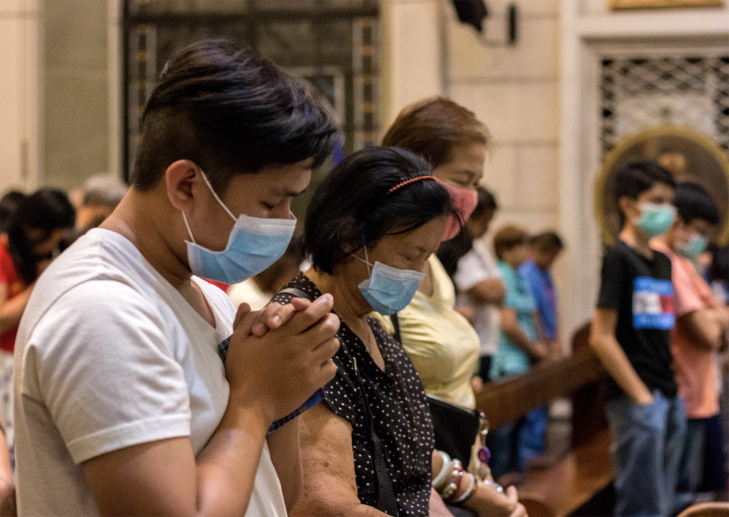 Những người đi nhà thờ đeo mặt nạ bảo vệ trong một thánh lễ tại Nhà thờ Giáo xứ Saint Andrew ở thành phố Parañaque vào ngày 14 tháng 3. ROMRICK DOMINICK