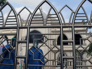 Các thành viên của Quân đội Indonesia mặc trang phục bảo vệ phun thuốc khử trùng ở những nơi công cộng và nơi thờ cúng như một biện pháp phòng ngừa chống lại sự lây lan của coronavirus ở Lhokseumawe. (Ảnh: Maskur Has)