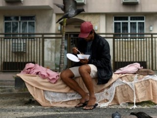 Một người đàn ông vô gia cư nhận thức ăn từ cư dân của khu ổ chuột Chapeu Mangueira ở Rio de Janeiro, Brazil