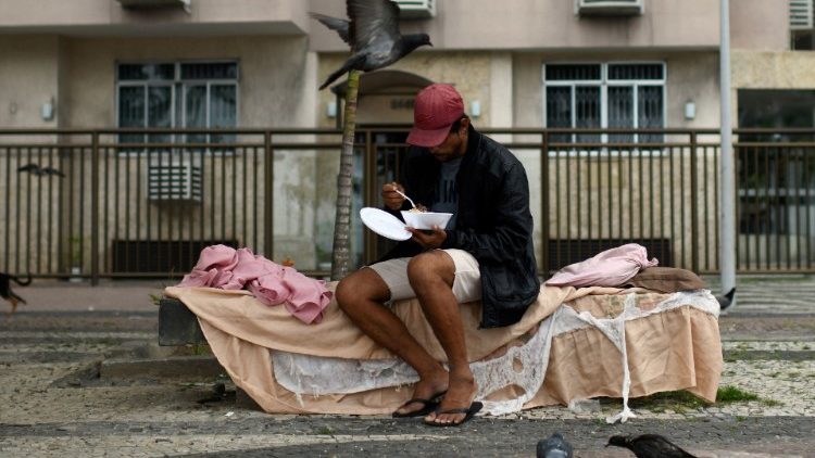 Một người đàn ông vô gia cư nhận thức ăn từ cư dân của khu ổ chuột Chapeu Mangueira ở Rio de Janeiro, Brazil