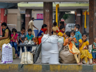 Các gia đình di cư chờ lên xe buýt ở Bangalore vào ngày 7 tháng 5 để trở về quê nhà sau khi chính phủ Ấn Độ nới lỏng khóa cửa toàn quốc được áp dụng như một biện pháp phòng ngừa chống lại coronavirus. (Ảnh: Manjunath Kiran / AFP)