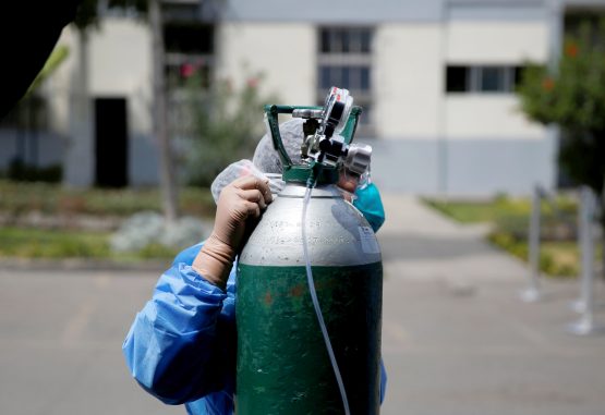 Một y tá điều chỉnh một bình oxy bên cạnh một chiếc lều cho bệnh nhân COVID-19 trong bãi đậu xe của một bệnh viện ở Lima, Peru, ngày 16 tháng 4 năm 2020. Khi các trường hợp coronavirus gia tăng ở hai thành phố lớn nhất của Amazon là Iquitos và Pucallpa, các nhà lãnh đạo Công giáo đấu tranh để tìm cách cung cấp cho người bệnh nhu cầu sức khỏe cơ bản nhất, oxy duy trì sự sống. (Tín dụng: Sebastian Castaneda / Reuters qua CNS.)