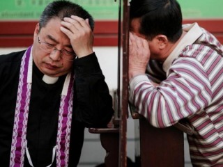 Một linh mục đang giải tội tại Nhà thờ Đức Mẹ Vô nhiễm Nguyên tội ở Bắc Kinh. Chính phủ Trung Quốc cho biết, ngoài việc đáp ứng các yêu cầu về sức khỏe sau khi bùng phát COVID-19, các linh mục phải "thuyết giảng về lòng yêu nước" như một điều kiện để mở lại nhà thờ của họ. (Ảnh: Damir Sagolj / Reuters - CNS.)