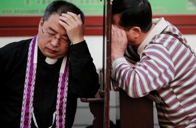 Một linh mục đang giải tội tại Nhà thờ Đức Mẹ Vô nhiễm Nguyên tội ở Bắc Kinh. Chính phủ Trung Quốc cho biết, ngoài việc đáp ứng các yêu cầu về sức khỏe sau khi bùng phát COVID-19, các linh mục phải "thuyết giảng về lòng yêu nước" như một điều kiện để mở lại nhà thờ của họ. (Ảnh: Damir Sagolj / Reuters - CNS.)