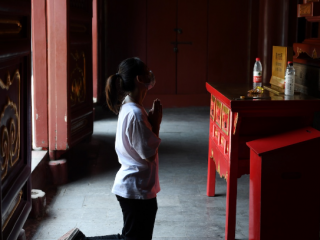Một người phụ nữ đeo mặt nạ cầu nguyện tại Đền Lama ở Bắc Kinh sau khi nó mở cửa trở lại vào ngày 10 tháng Sáu. Ngôi đền đã đóng cửa vào ngày 24 tháng 1 khi chính quyền đóng cửa các điểm du lịch và các địa điểm khác để chứa coronavirus. (Ảnh: Greg Baker / AFP)