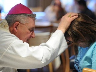 Trong bức ảnh tập tin năm 2014 này, Đức cha David A. Zubik của Pittsburgh nghe thấy lời thú tội của một phụ nữ trẻ trong một cuộc mít tinh ủng hộ giới trẻ và Thánh lễ tại Trung tâm Verizon ở Washington. (Ảnh CNS / Leslie Kossoff)