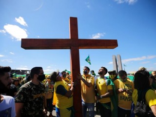 Những người biểu tình giữ một cây thánh giá trong một ngày 19 tháng 7 năm 2020, cuộc biểu tình ở Brasípa, Brazil, liên quan đến hành động của chính phủ trong đại dịch coronavirus. (Tín dụng: Adriano Machado / Reuters)