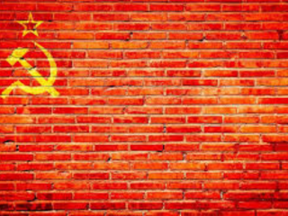 Một bức tường gạch đỏ với búa và liềm màu vàng, biểu tượng của chủ nghĩa cộng sản. (Ảnh: pxfuel.com)