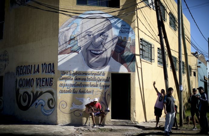 Một người đàn ông chơi guitar bên dưới bức tranh tường của Giáo hoàng Francis trong một cuộc khóa cửa do chính phủ ra lệnh để ngăn chặn sự lây lan của coronavirus mới ở Buenos Aires, Argentina, Thứ Tư, ngày 29 tháng 4 năm 2020. (Tín dụng: Natacha Pisarenko./AP)