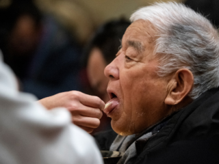 Một tín đồ được rước lễ khi tham dự Thánh lễ đêm Giáng sinh tại Nhà thờ Xishiku ở Bắc Kinh vào ngày 24 tháng 12 năm 2019.