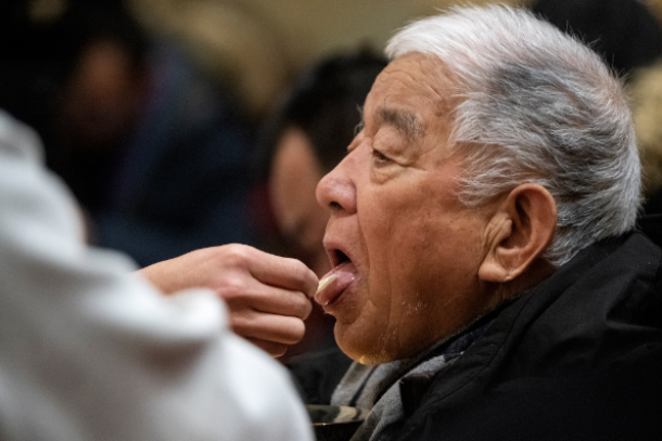 Một tín đồ được rước lễ khi tham dự Thánh lễ đêm Giáng sinh tại Nhà thờ Xishiku ở Bắc Kinh vào ngày 24 tháng 12 năm 2019.