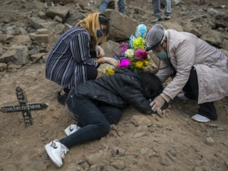 Aurora Davila, phải, an ủi đứa cháu gái 15 tuổi đau buồn Tatiana Palomo của cô khi cô nằm trên mộ của người cha đã chết vì coronavirus mới, trong một lễ mai táng tại nghĩa trang "Martires 19 de Julio" ở Comas, trên ngoại ô Lima, Peru, Thứ Bảy, ngày 4 tháng 7 năm 2020. Peru có tỷ lệ tử vong do COVID-19 trên một triệu người cao nhất ở châu Mỹ, trên Chile, Hoa Kỳ, Brazil và Mexico. (Nguồn: Rodrigo Abd / AP)