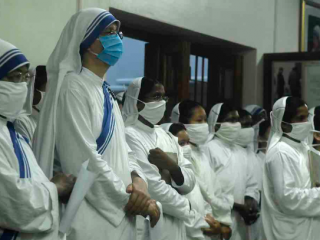 Các nữ tu Dòng tu từ thiện đeo mặt nạ cầu nguyện tại lăng mộ của Mẹ Teresa để đánh dấu kỷ niệm 110 năm ngày sinh của bà ở Kolkata vào ngày 26 tháng 8. (Ảnh: Dibyangshu Sarkar / AFP)