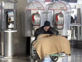 Một người đàn ông sử dụng xe lăn nói chuyện trên điện thoại di động của mình tại nhà ga Termini ở Rome vào ngày 27 tháng 1 năm 2012, ảnh tệp. Caritas Rome và Hội Chữ Thập Đỏ Ý đã mở một trung tâm kiểm tra và giữ COVID-19 cho những người vô gia cư tại nhà ga. (Nguồn: Alessandro Bianchi / Reuters qua CNS)